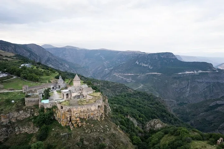 Aerial view of Tatev Monastery perched on a steep mountain cliff.