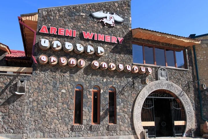 Exterior view of Areni Winery building with stone walls and signs.