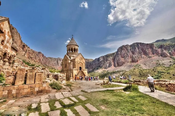 Noravank Monastery nestled in a rocky gorge with visitors exploring.