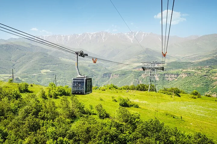 Wings of Tatev cable car suspended over a green valley.
